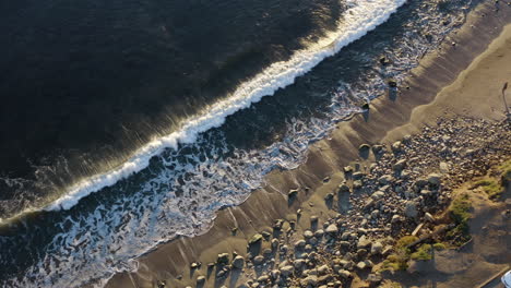 drone aéreo dolly sobre las olas chocando contra la costa de pch malibu