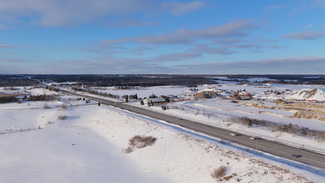 Drone-luchtfoto van een met sneeuw bedekte grindgroeve langs Highway 10 in Caledon, Ontario, met een groeflandschap, open terrein, winterlandschap, nabijgelegen weg en landelijke omgeving.