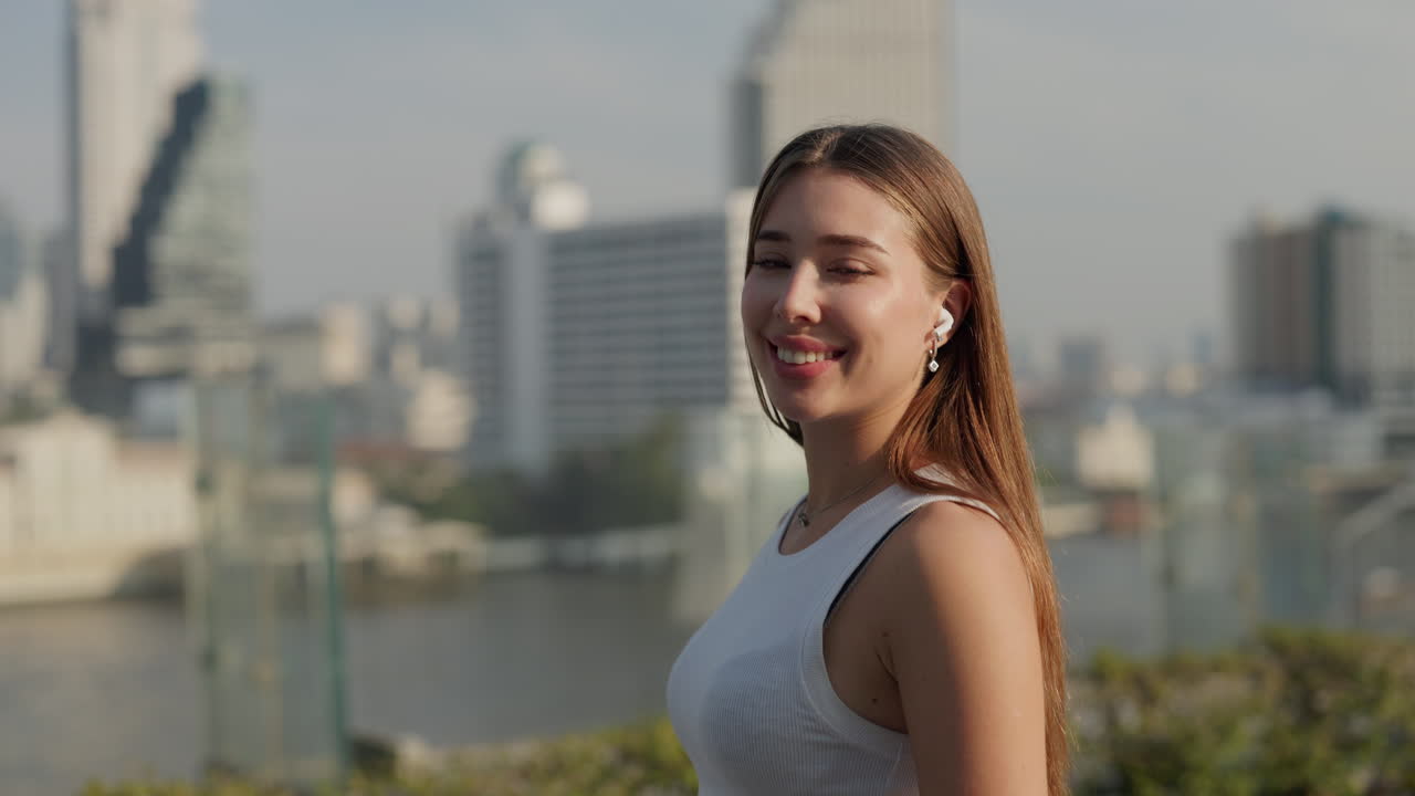 Woman smiling on a rooftop with city view