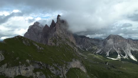 seceda mountains in the italian dolomites with the clouds covering the steep pinnacle shaped cliffs