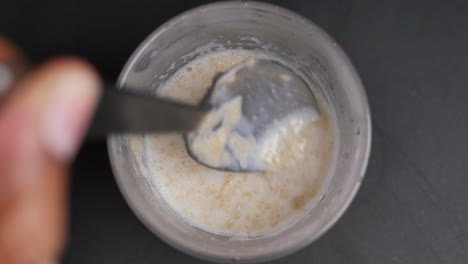 oats, banana and milk in a bowl on black background