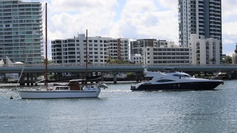 yachts moving past cityscape on sunny day