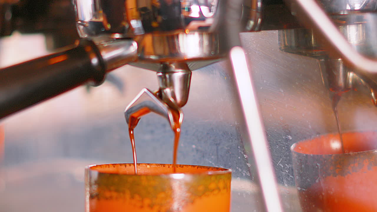 Tampilan Jarak Menengah Portafilter Menuangkan Kopi dalam Gerakan Lambat dari Mesin Espresso ke Cangkir Kecil untuk Membuat Flat White. Barista Kafe Profesional Berkualitas Tinggi Membuat Minuman Pagi Panas