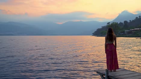 Chica-Caminando-Por-El-Muelle-Al-Espectacular-Atardecer-En-El-Lago-De-Atitlán,-Guatemala