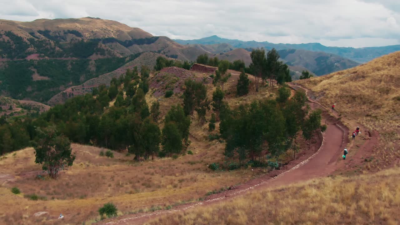 Escursionisti che camminano su un antico sentiero Inca che porta alle rovine di Huancaure vicino a Cusco, Perù.