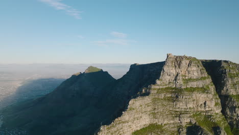 Massive-rock-mountain-ridge-with-flatted-top.-Fly-around-famous-Table-mountain.-One-side-lit-by-sun,-one-in-shadow.-Cape-Town,-South-Africa