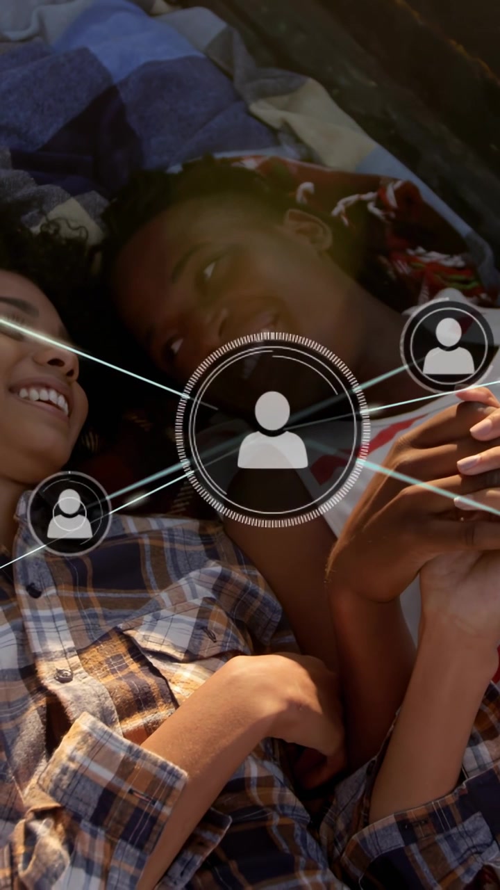 Vertical video: Two teens touching phone, exploring social network overlay with nodes multiplying
