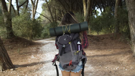 Hiking-girl-walking-on-forest-path-for-camping