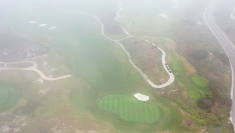 Vista-Aérea-Cinematográfica-Del-Campo-De-Golf-Revelada-A-Través-De-La-Niebla