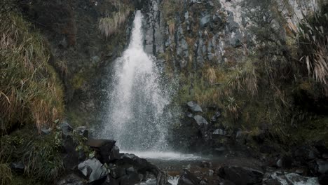 waterfall cascading down over river rocks in cayambe coca national park, papallacta, ecuador - tilt down