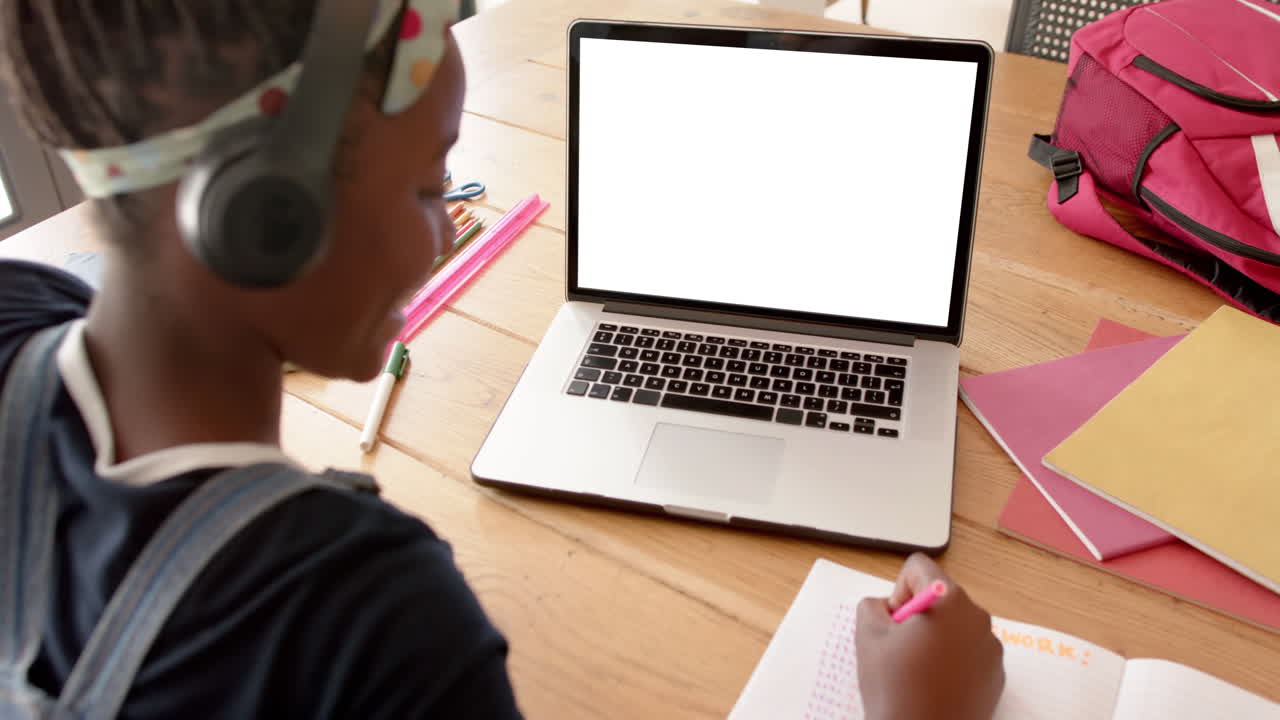 Composition of african american schoolgirl on laptop online learning with blank screen