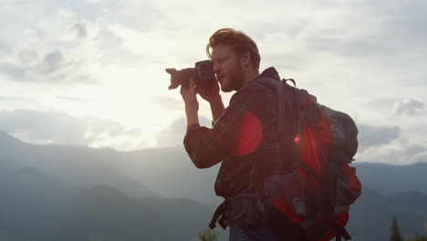 un joven turista toma una foto en el paisaje de las montañas. un fotógrafo en la naturaleza.