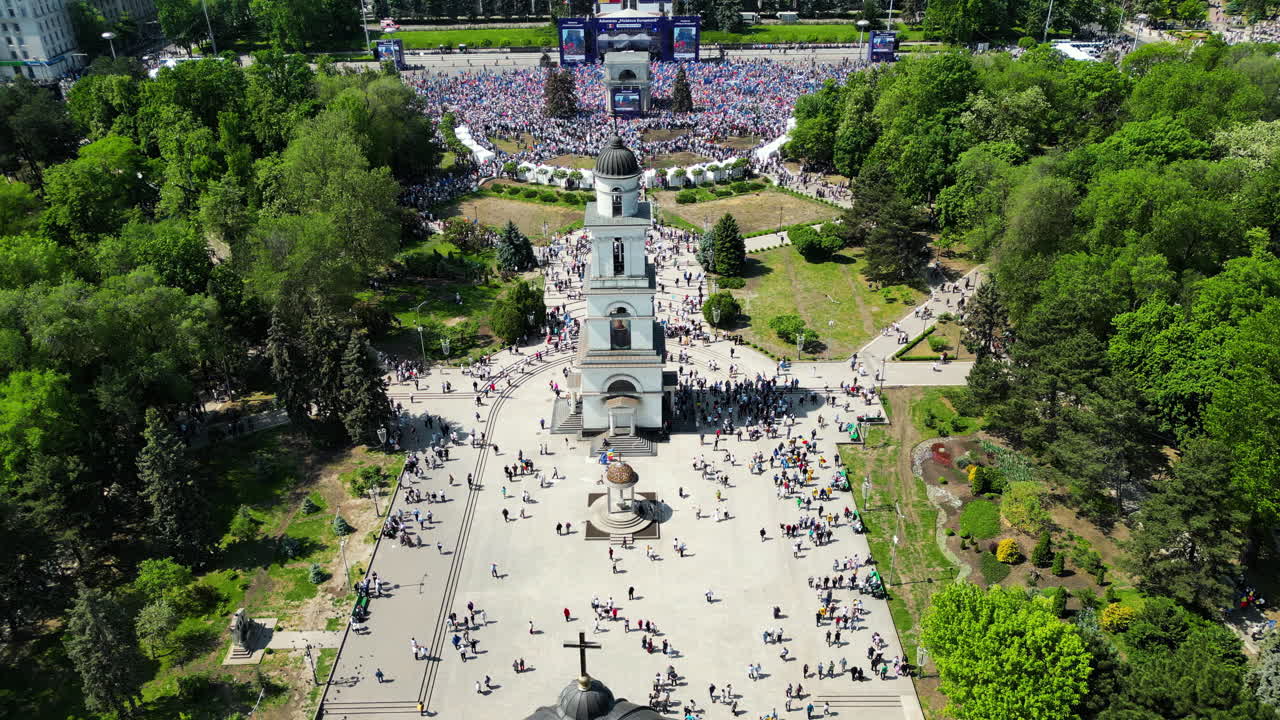 CHISINAU, MOLDOVA - 21 MAY, 2023: Aerial drone view of the rally in support of the country's European integration in Chisinau, Moldova. Thousands of people in the city downtown, greenery, EU and national flags