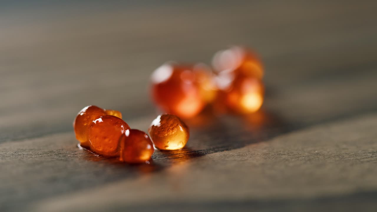 Nahaufnahme von frischem Lachsrogen auf einer dunklen Holzoberfläche