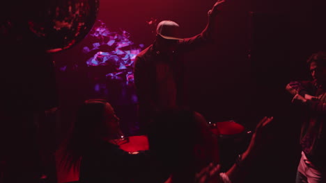 gente bailando en un club nocturno con un dj
