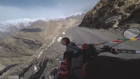 pov of riding motor bike on dangerous cliff hanger himalayan roads of spiti valley in himachal pradesh india