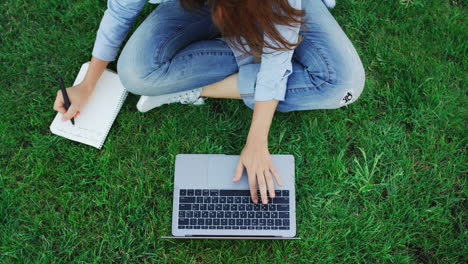 woman freelancer working on laptop in summer park