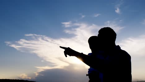 silhouette of father and child at sunset