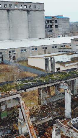 aerial view of an old factory ruined building with debris and broken bricks with collapsed roof. old industrial building for demolition. vertical video