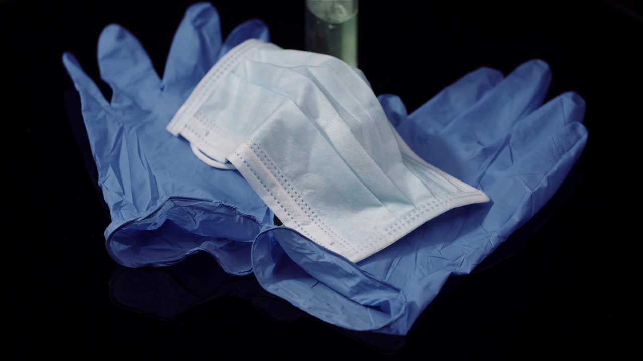 máscara protectora aislada sobre fondo negro máscara médica giratoria guantes protectores