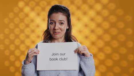 book club president holds message urging people to join them, studio background