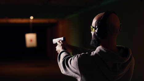 cliente de la galería de tiro usando pistola para golpear objetivos