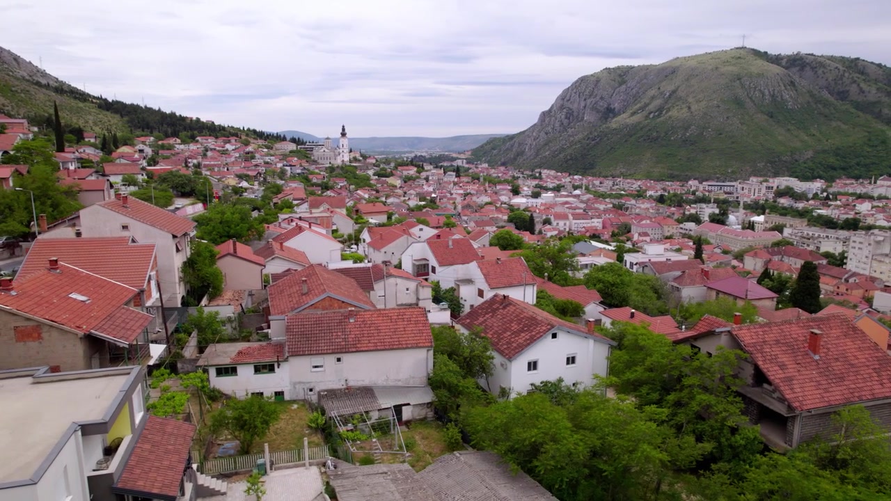 Drone kiertää Mostarin laaksoa, joka on täynnä punakattoisia taloja dramaattisten vuorijonojen välissä, ilmakuva, Bosnia ja Hertsegovina