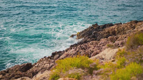 Las-Olas-Del-Océano-Chocan-Contra-Las-Rocas-De-La-Montaña-En-Un-Día-Soleado