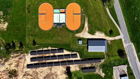 wastewater facility with solar panels on a sunny green landscape, aerial view