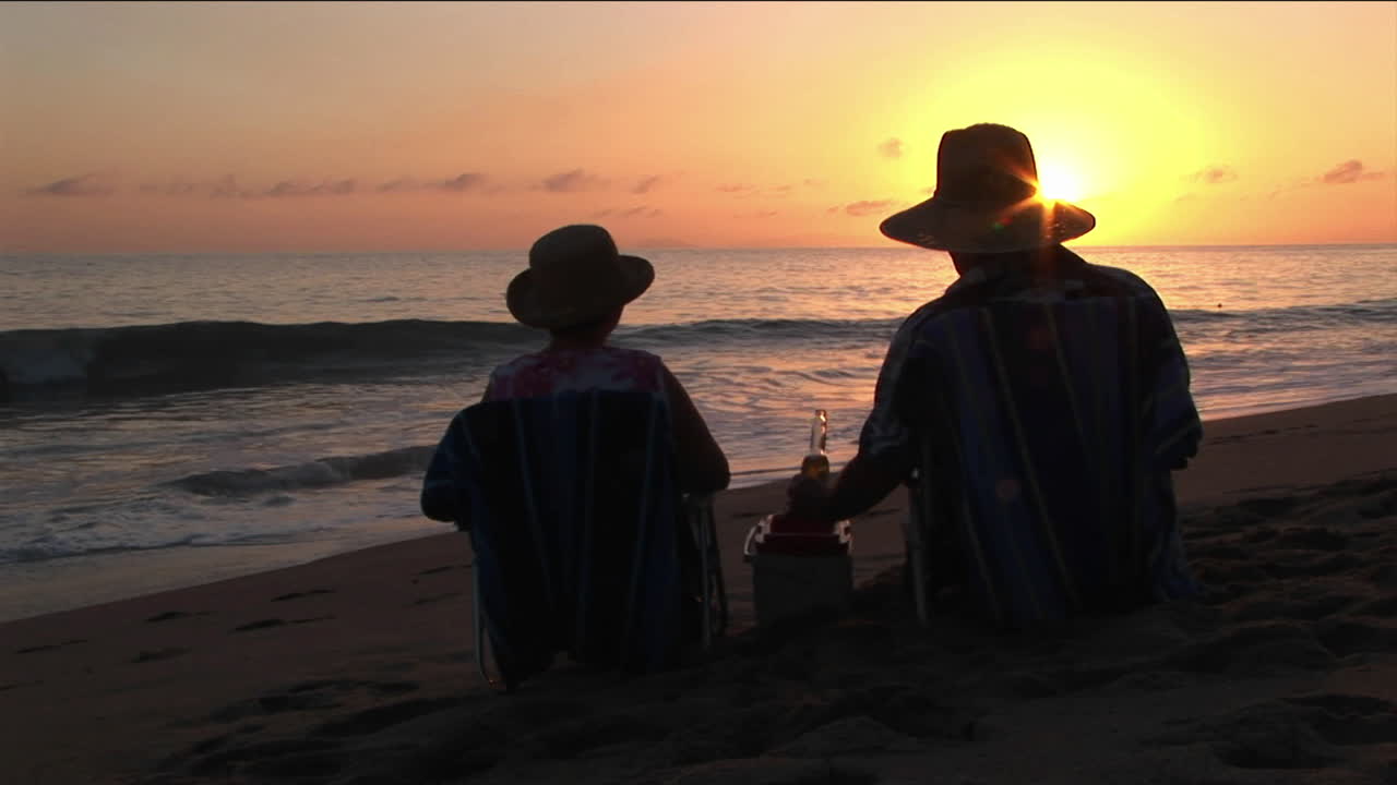 해변 의자에서 바다를 건배하는 커플