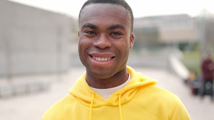 African young man standing outdoors and smiling