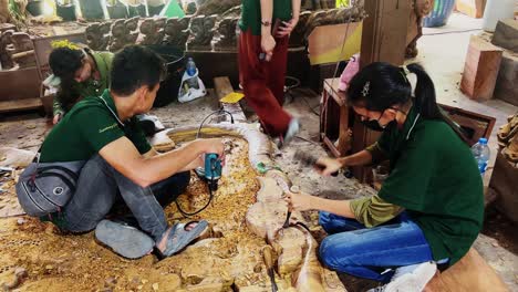 talented artisans collaboratively carving intricate wooden sculptures