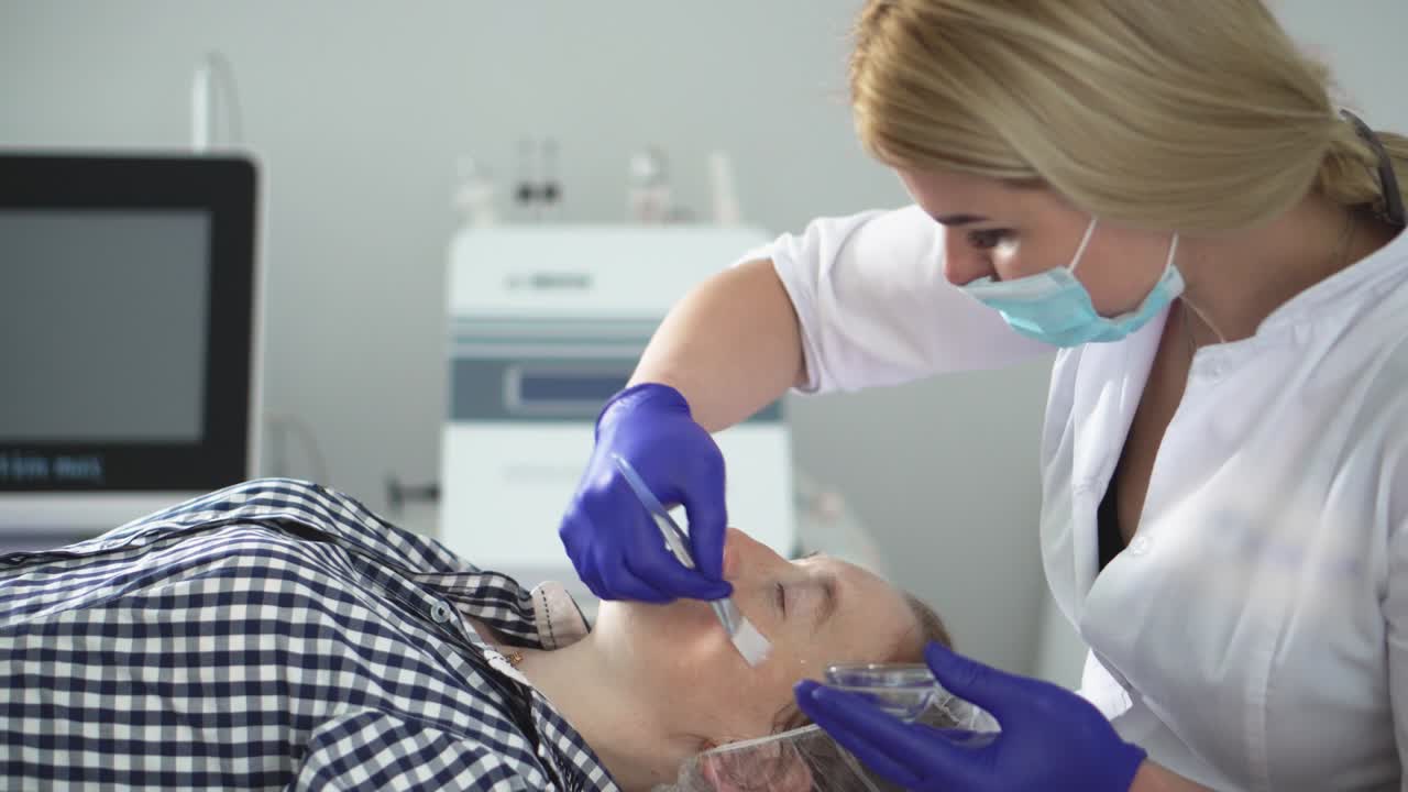 procedimiento de hardware en cosmetología. peeling, fonoforesis, masaje y estiramiento facial en una clínica de belleza. el cosmetólogo suaviza las arrugas con microcorrientes.