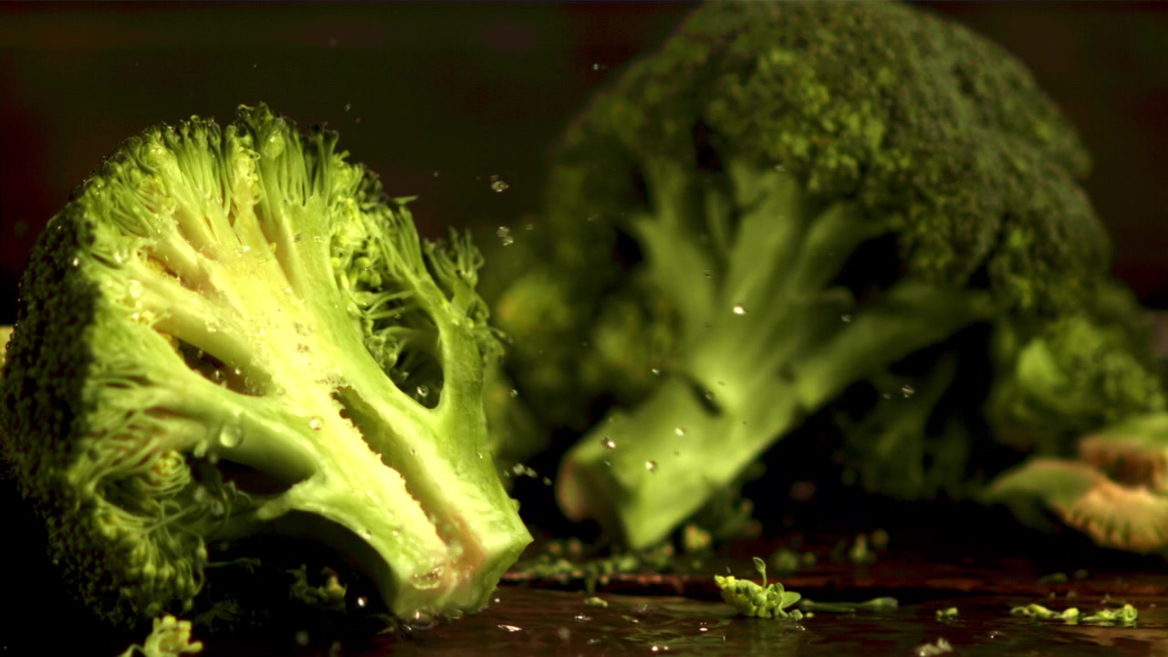 Close-up of Water Drops Falling on Fresh Green Broccoli