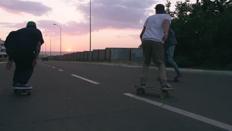 group of young people skateboarding on the road in the early morning, cinematic shot, slow motion