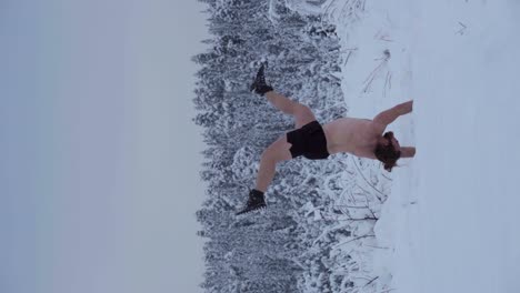 a man is executing a handstand amidst the deep snow - vertical shot