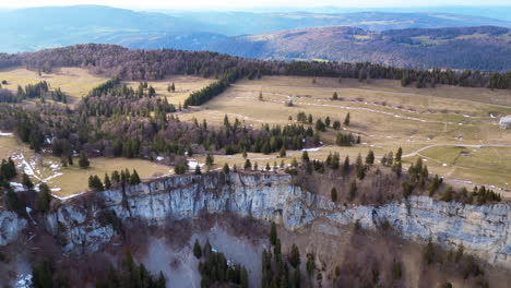 Aerial-of-rock-cliffs-with-hilly-meadow-landscape,-Wandfluh-Solothurn,-Switzerland