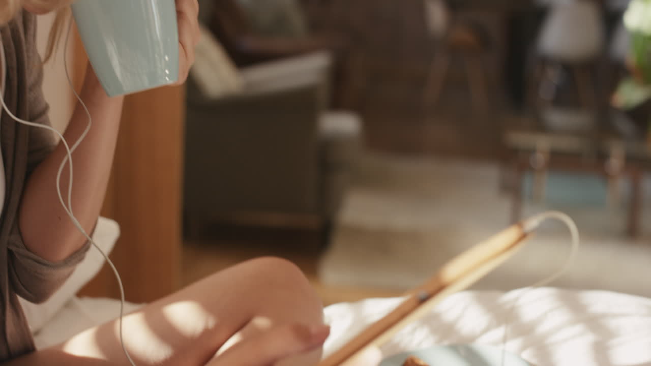 디지털 태블릿 기술을 사용하여 집에서 아름다운 금발 여성