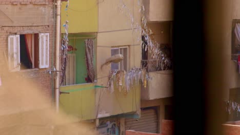 vista por la ventana de una casa de apartamentos con balcones en el área pobre de el cairo