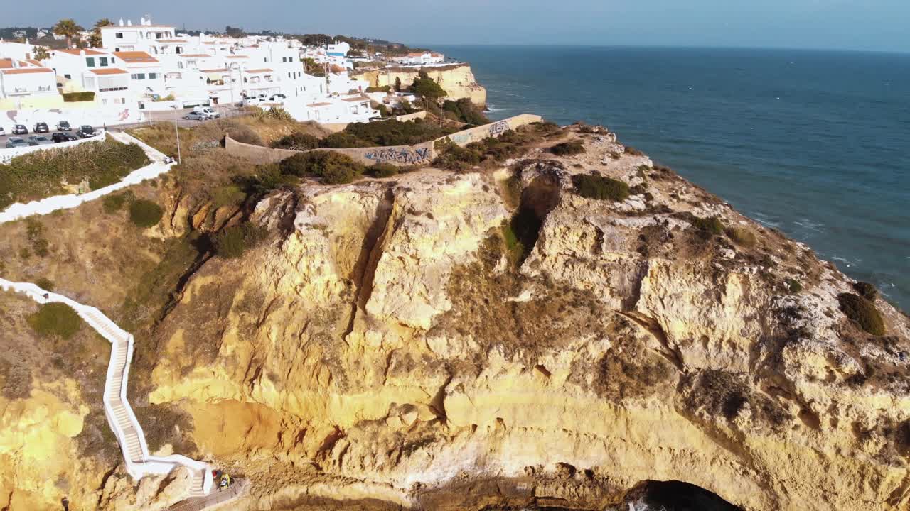 vista panorámica de la playa paraíso, los acantilados y el camino cuesta abajo en carvoeiro - toma de revelación panorámica aérea