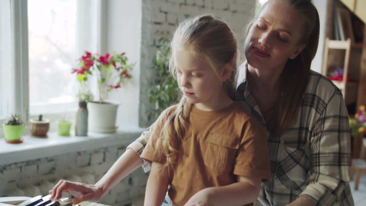 madre y hija se divierten tocando melodías divertidas con sintetizador