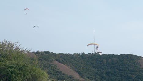 Hombre-Con-Paracaídas-Amarillo-Aterriza-Contra-El-Cielo-Azul-Claro