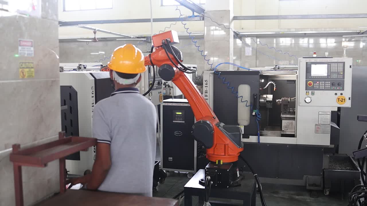 Factory Worker Operating Industrial Robot in Manufacturing Facility