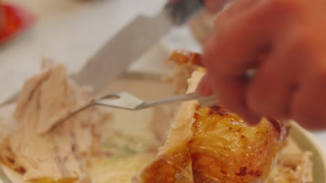 Slices of Chicken Meat Being Carved in Slow Motion with Succulent Pieces Removed and Placed Ready to Plate for Guests. Chef Using Long Fork and Carving Knife. Traditional British Sunday Dinner.