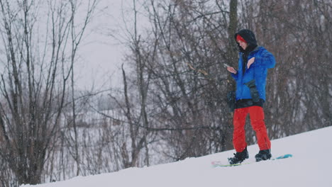 Usa-Tu-Teléfono-Inteligente-Para-Tomar-Fotografías-De-Paisajes-Mientras-Haces-Snowboard-En-La-Pista-De-Esquí