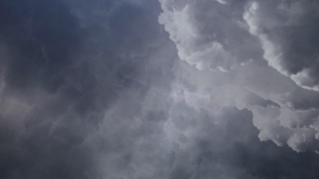 하늘의 어두운 구름 속에서 번개가 번쩍이는 모습