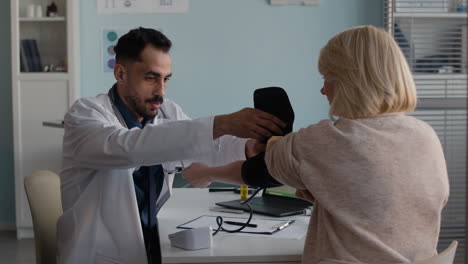 doctor checking patient's blood pressure
