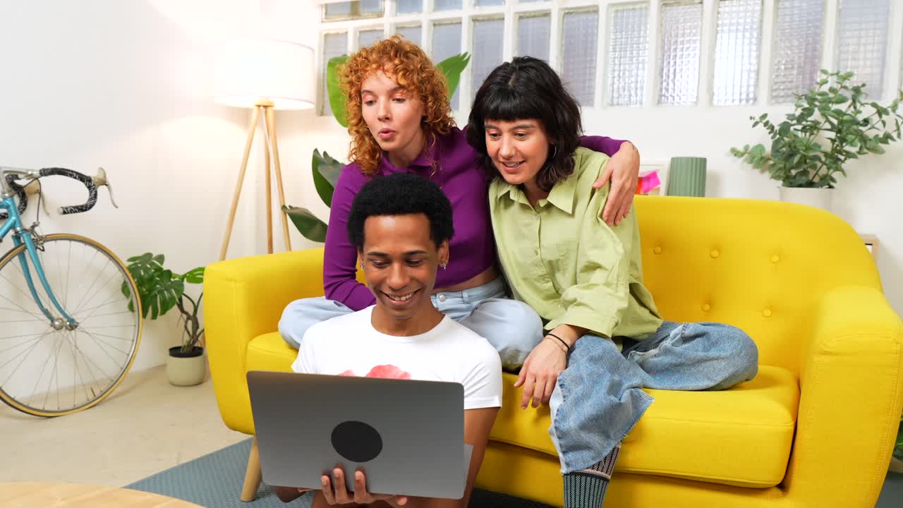 Friends having fun with a laptop at home