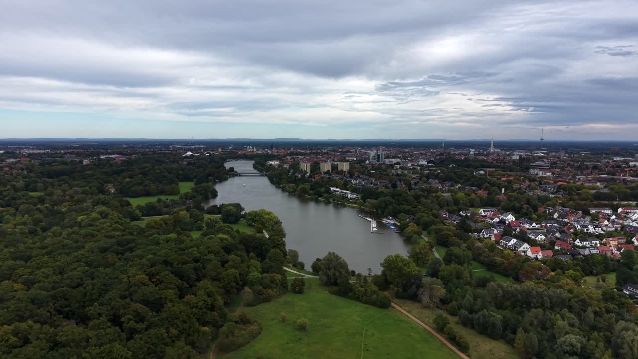 Natural lake near Americans neighborhood at cloudy day. Aerial panorama view. Green trees in late summer with dense clouds at sky
