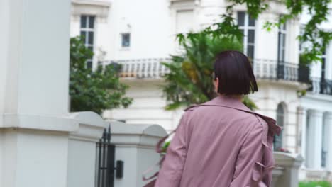 fashion conscious young woman walking along city street